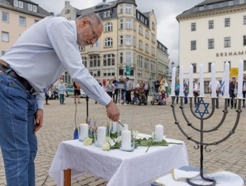 Der Gemeinderatsvorsitzende der Jüdischen Gemeinde Chemnitz, Igor Gurevych, beim Entzünden einer Kerze. 
