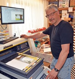 Matthias Bilz in seiner Werkstatt in Cämmerswalde. Mit einem speziellen Hochleistungsdrucker kann er Bildmotive auf dünne Holzplatten aufdrucken. 