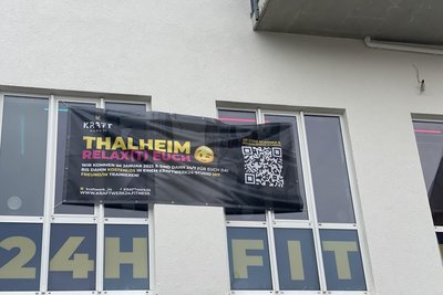 Plakat vor dem Fenster des neuen Studios: Nicht nur der Text hat es in sich. Hinter dem QR-Codes des Plakates steckt eine gezielte Marketingaktion.