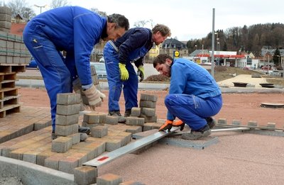 Dietmar Gruschwitz, Winfried Schneider und Danny Remter (von links) bauen den Fußweg entlang der Bahnhofstraße.