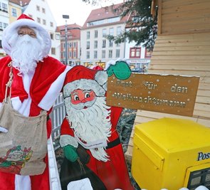 Freibergs Weihnachtsmann mit seinem hölzernen Abbild an der Krippe auf dem Obermarkt.