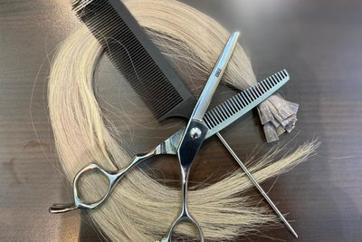 Das Werkzeug der Friseurin: Schere, Kamm und Strähnen.