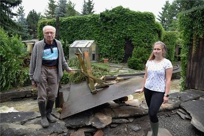 Hochwasserschäden auf dem Grundstück von Günther Haller (links) an der Bachstraße in Oelsnitz. Durch das Grundstück fließt der Gerberbach. Enkeltochter Sandra Jacob unterstützte beim Aufräumen. 