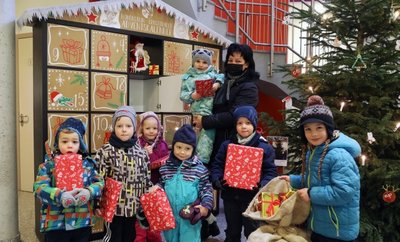 Die Kinder vom Ökumenischen Kindergarten Sonnenblume mit Erzieherin Anja Meyer am Adventskalender am Rathaus. 