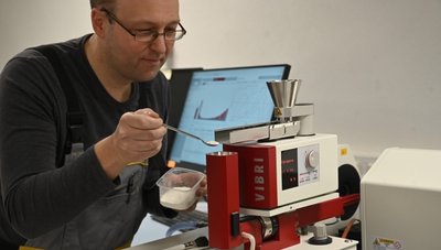 Baustoffprüfer Jörg Heinicke kontrolliert mit einem Lasergranulometer die Körnung von Mörtel. 