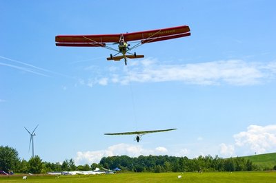 Ein Starrflügler - besondere Drachenart - wird vom Ultraleichtflugzeug auf Höhe geschleppt.