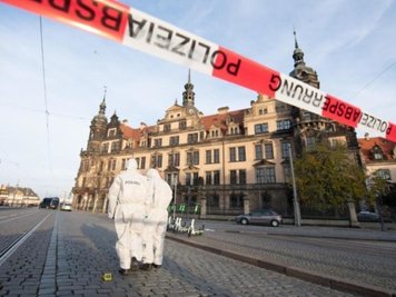 Zwei Mitarbeiter der Spurensicherung stehen im November 2019 vor dem Dresdner Residenzschloss mit dem Grünen Gewölbe hinter einem Absperrband. 