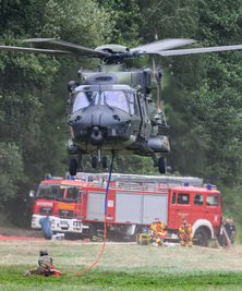Auch die Bundeswehr unterstützt mit ihren Kräften die Brandbekämpfung im Naturpark - hier im Foto ein Hubschrauber, der mit einem Löschwasser-Außenlastbehälter am Ufer der Elbe abhebt.