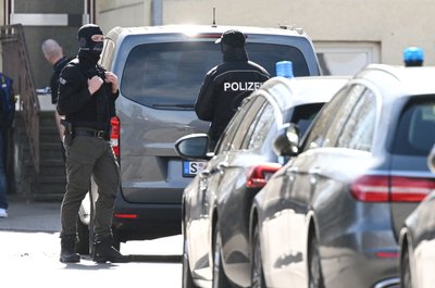 Einsatzkräfte der Polizei stehen an Einsatzfahrzeugen. Bei einer Durchsuchung im Auftrag der Bundesanwaltschaft ist im baden-württembergischen Reutlingen ein Beamter eines Spezialeinsatzkommandos (SEK) durch einen Schuss verletzt worden. 