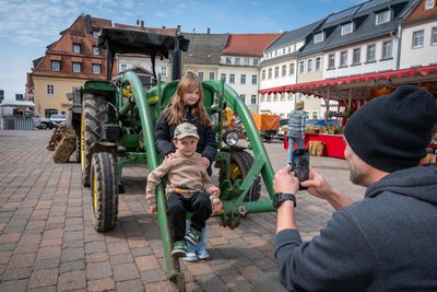 Hans und Schwester Merle lassen sich vom Papa am Traktor fotografieren.