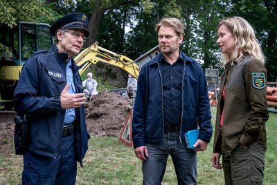 Kommissar Robert Winkler (Kai Scheve) und Försterin Saskia Bergelt (Teresa Weißbach) ermitteln auch in der 16. Folge des Erzgebirgskrimis. Hier sind sie in einer Szene der Folge zu sehen, als es um einen Leichenfund am Burggraben ging. Ortspolizist Rainer Wagner (Thomas Bading, l.) trug seine Erkenntnisse bei.