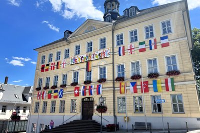 Das Rathaus in Hainichen zur Fußball-EM 2024, mit den Flaggen aller 24 teilnehmenden Teams.