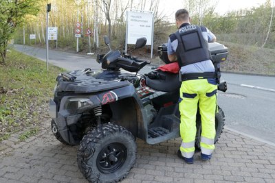 Ein Polizist begutachtet das am Neefepark in Chemnitz verunfallte Quad.