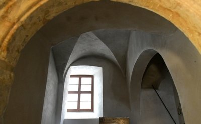 Das Kreuzgewölbe und der Sandsteinbogen sind historische Details, die erhalten geblieben sind.
