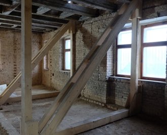 Beamtenwohnhaus: Noch ist das Gebäude eine leer				 	 ©/Fotograf	 Cristina Zehrfeld Bildunterschrift	 Die Wände im Beamtenwohnhaus sind unterschiedlich dick, die Bausubstanzen wechseln. Das verkompliziert die Sanierung. Die Holztreppengeländer werden erhalten, die Holzeingangstüren originalgetreu nachgebaut - aber so, dass sie nach außen hin öffnen. Das verlangt der Brandschutz. Bild		Anzeige:  freie Hülle. Fast alle Wände in dem Fachwerkhaus wurden entfernt, eine Behelfskonstruktion stützt die Mauern. Die alten Deckenbalken sind größtenteils intakt und können bleiben, darauf kommen Stahlbetondecken.