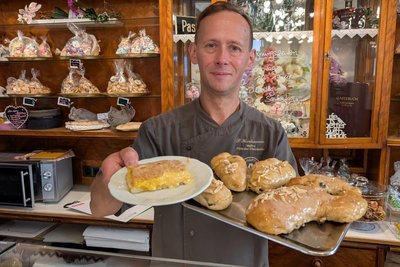 Pat Hartmann mit Freiberger Eierschecke und dem Bauerhasen, den bekanntesten Köstlichkeiten seines Cafés.