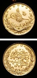 Goldmünze mit arabischen Schriftzeichen, die zum Kettenanhänger umfunktioniert wurde (Durchmesser etwa zwei Zentimeter)