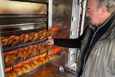Die Luft muss raus. Tibor Baumgärtner durchsticht mit einer Gabel die Broilerhaut. Bei 80 bis 100 Grad Celsius in dieser Grillnähe oft eine schweißtreibende Angelegenheit.