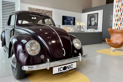 Der VW Käfer inmitten von Designmöbeln, Porträts, Gemälden, Geräten und co.