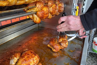 Geübte Hände. Mit der Geflügelschere wird der etwa anderthalb Stunden lang gegrillte Broiler halbiert.