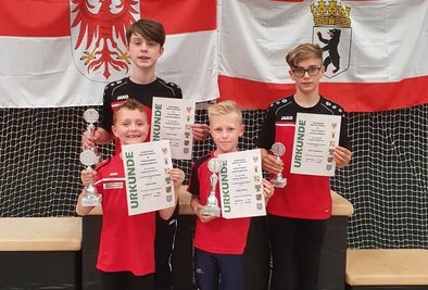 Die Kunstradfahrer Jonas Locke, Linus Naumann (hinten von links), Felix Locke und Jonas Köhler (vorne von links) präsentieren stolz ihre Pokale und Urkunden. 