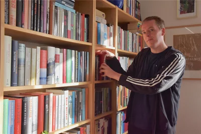 Thoralf Kuhnt an einem seiner vielen Bücherregale in seiner Wohnung.
