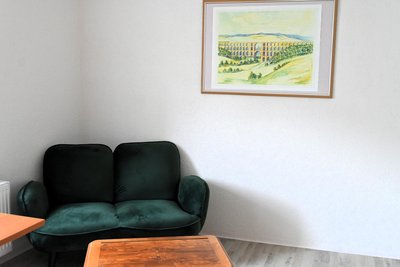 Blick ins künftige Göltzschtalbrücken-Appartement mit dem grünen Plüsch-Sofa.