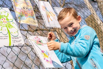 In der Auerbacher Kita "Mischka" malten Kinder in der Notbetreuung Bilder für Spielgefährten, von denen sie derzeit getrennt sind. Damit diese sie auch sehen können, wurden sie am Zaun vor der Einrichtung angebracht - wie von Lennox (6).