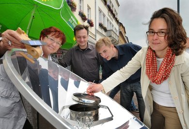 Die Grünen kochten am Montag auf dem Frankenberger Markt im Spiegel mit Sonnenenergie: Renate Sauer, Urs Moesenfechtel, Sebastian Walter und Landesvorsitzende Claudia Maicher (v. l.).