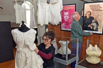 Michaela Kruse und Andreas Seltmann bauen die Ausstellung „Korsett & Emanzipation“ auf.