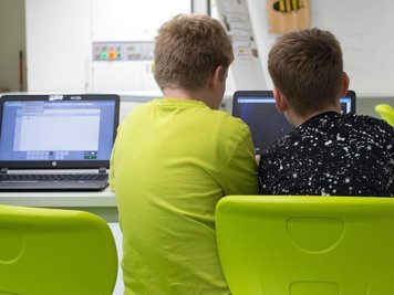  
          Zwei Schüler arbeiten an einem Laptop.