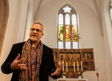Künstler Michael Triegel - im Hintergrund sein gestaltetes Glasbildfenster. 