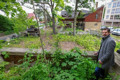 Diakonie-Sprecher Lars-Christian Trommer zeigt von der Terrasse aus den verwilderten Garten. Foto: Andreas Kretschel