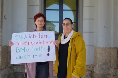 Anja Olbrich (links) und Ines Müller mit einem Plakat. Es spielt auf einen Punkt in der Begründung der CDU an, der neuen Oberbürgermeisterin einen verlässlichen Stellvertreter an die Seite stellen zu wollen, auch, weil sie alleinerziehend sei. „Damit wird sie in eine Schublade gesteckt und ihr die Kraft für das Amt abgesprochen“, sagt Olbrich.