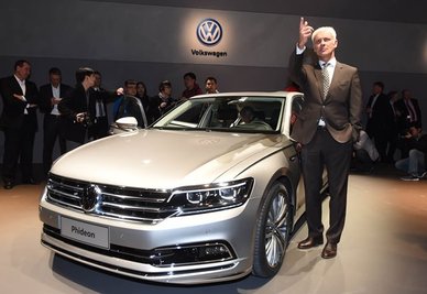 VW-Chef Matthias Müller zeigt sich beim Volkswagen-Konzernabend neben einem VW Phideon.