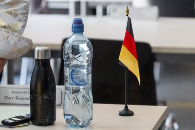 Eine Deutschland Flagge steht auf dem Tische eines Mitglieds des Kreistags. Kreistagssitzung Landkreis Sonneberg mit Vereidigung von Landrat Robert Sesselmann (AfD).