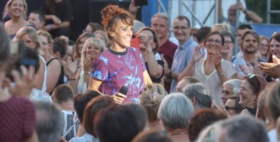 Die französische Sängerin Zaz beginnt ihr Konzert auf dem Theaterplatz mit einem Bad in der Menge. Sie taucht irgendwo auf und geht singend durch die Reihen. Ihr Publikum begeistert sie mit ihrer Kraft und Ausdrucksstärke. Rund 100 Minuten lang bietet sie eine Show mit vollem Körpereinsatz. 