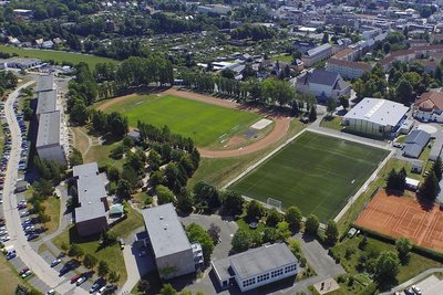 Ein Luftbild von 2015 zeigt das Stadtumbaugebiet am Stadion in Oelsnitz mit Sportanlagen und - vor den Wohnhäusern - Grundschule und Kita.