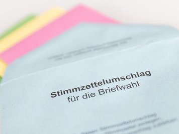            Verschiedene Stimmzettel stecken in einem Stimmzettelumschlag für die Briefwahl.