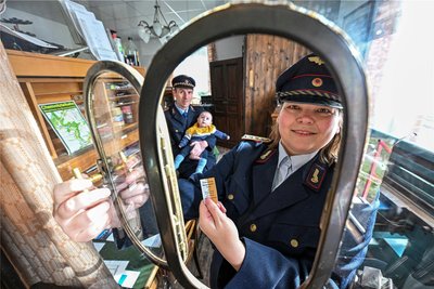 Die Eisenbahnfreunde Chemnitztal betreiben im ehemaligen Bahnhof in Markersdorf-Taura ein Museum. Conny Helmert in der alten Fahrkartenausgabe, dahinter ihre Familie.