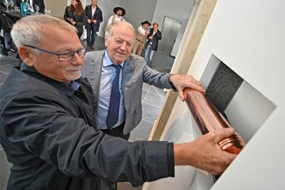Investor, Unternehmer und Mäzen Siegfried Weishaupt , rechts, verlegt mit Architekt Claus Höhn die Zeitkapsel in der Mauer neben dem Eingang.
