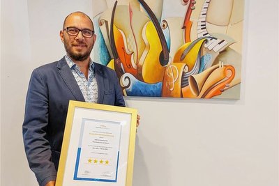 Der neue Hoteldirektor Gökhan Yasa mit dem Vier-Sterne-Zertifikat für das Haus Schwarzbachtal in Erlbach.