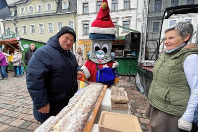 Bürgermeister Thomas Firmenich schnitt den zwei Meter langen Riesenstollen aus dem Ofen der Frankenberger Backwaren GmbH an. Verkäuferin Sabine Breul und das Maskottchen Fränki assistierten dabei. Der Erlös des Stollenverkaufs kommt der Kinder- und Jugendfeuerwehr der Stadt zugute.