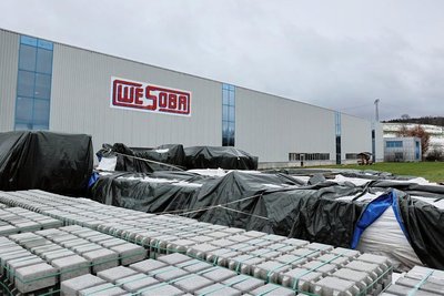  Teile der riesigen Presse, die in einer neuen Halle aufgestellt werden soll, warten gut verpackt auf ihre Montage. Und auch Baumaterial liegt schon bereit. 