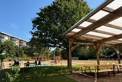 Das Klassenzimmer mit Dach ermöglicht Unterricht im Grünen. Links der Spielplatz, rechts der Sportplatz.
