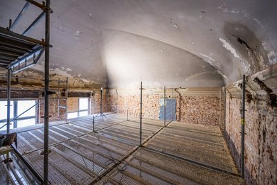 Ein Bild von dieser Woche: Die Kuppeldecke liegt wieder frei. Darunter steht ein Gerüst, auf dem der Restaurator arbeiten kann.