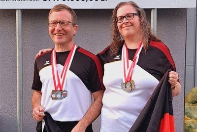 Mit Partnerin und Deutschlandflagge: Frank Grunert mit Assistentin Sylke Wechler, die ihm bei Wettkämpfen die Kugeln reicht und Tipps zu deren Lauf übermittelt.