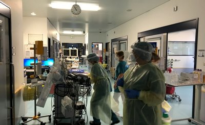 Blick auf den Gang der Intensivstation im Zschopauer Haus. Oberärztin Dr. Barbara Atmanspacher (vorn) und Pflegerinnen bereiten sich darauf vor, einen beatmeten, auf dem Bauch liegenden Patienten zu drehen. 