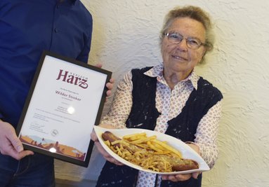 Die 91-jährige Herzbergerin Käthe Neukirch präsentiert am 15.09.2017 in Herzberg (Niedersachsen) das neue Harzer Regionalgericht "Wilder Stinker". Dabei handelt es sich um eine durch heimische Kräuter verfeinerte Wildschwein-Bratwurst. Sie wird mit Harzer Käse überbacken und dann an einer mit Harzer Beerenlikör verfeinerten Currysauce serviert