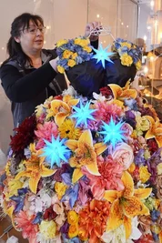 Mitarbeiterin Marion Knaute schafft Deko mit Sternen und Kunstblumen.